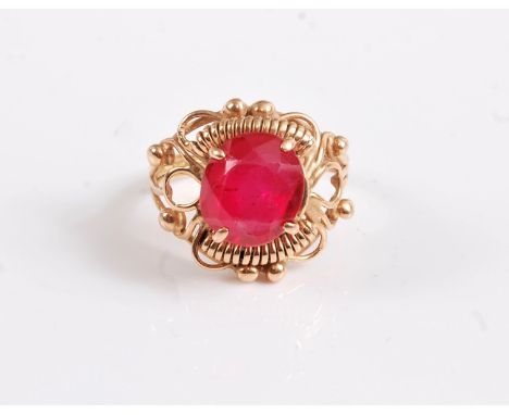 A synthetic ruby ring, the off round synthetic ruby in a four claw mount, within a wirework and bead framework, with tapering