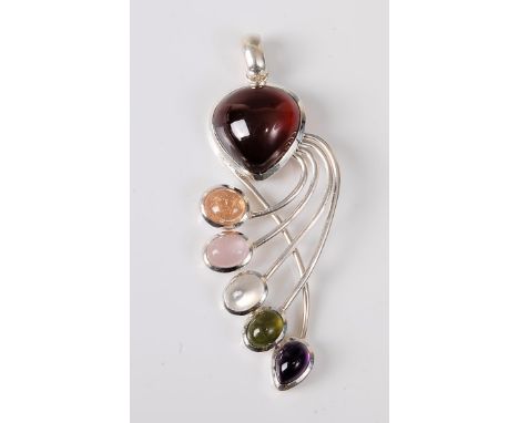 A multi gemset silver pendant, the pear shaped garnet cabochon in rubover mount, with five curling branches each supporting a