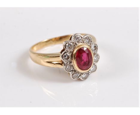 An 18ct ruby and diamond ring, the oval ruby in rubover mount, surrounded by round brilliant cut diamonds, total weight of di