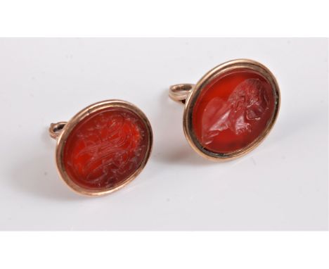 Two carnelian fobs/seals, the first oval intaglio fob in collet mount, 22mm long, and four prong raised loop, together with a