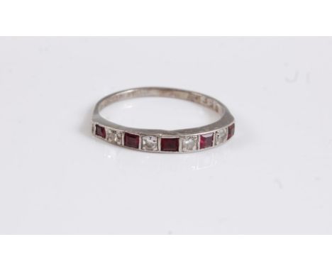 An 18ct and platinum ruby and diamond ring, the alternating square cut rubies and single cut diamonds, channel set with milli