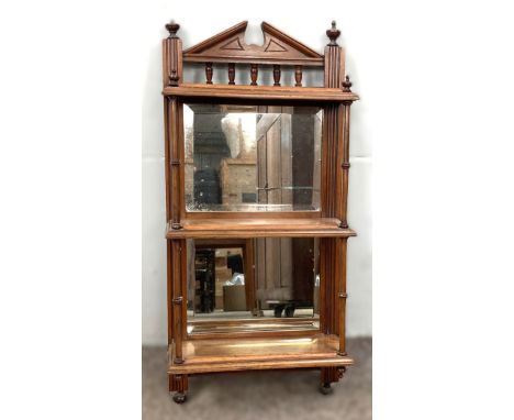 A mahogany hanging shelf of architectural form with three tiers and bevelled mirror backs, 62 x 29 x 13 cm.  The Alastair & S