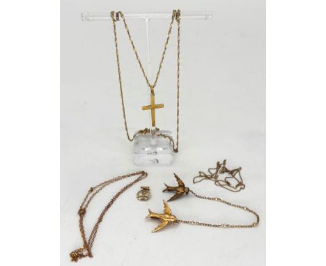 A 9ct gold necklace and crucifix, 2.7g, and other yellow metal chains and two bird brooches connected by chain with seed pear