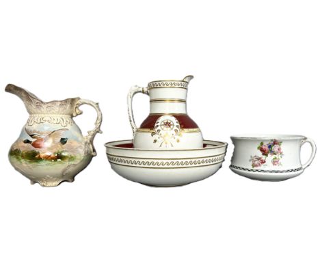 A circa 1900 pitcher depicting a duck in flight, 30 cm, also a wash basin and pitcher, and a chamber pot, (4).  The Alastair 