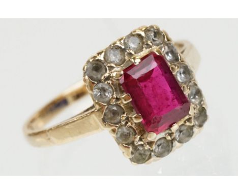 9ct gold hallmarked synthetic ruby and white stone cluster ring. The ring being set with a rectangular step cut synthetic rub