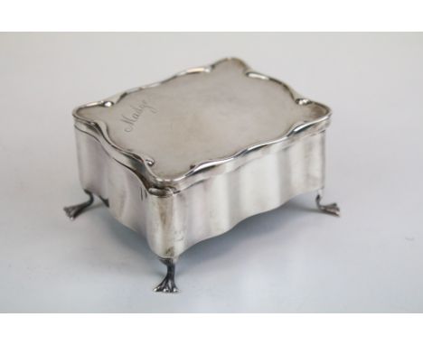 Asprey of London - A silver jewellery box / casket of shaped form, with fitted interior, raised on four feet, inscribed 'Madg