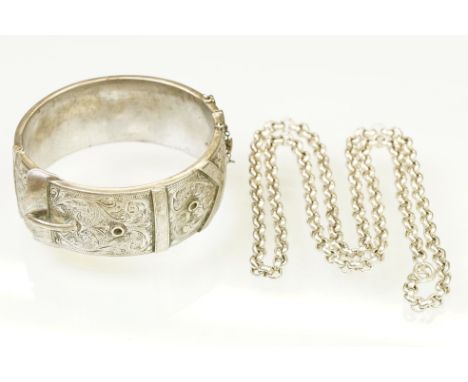 Silver hallmarked buckle bangle handing applied and engraved details with a hinged mechanism. Hallmarked Birmingham, date let
