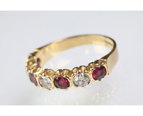 18ct gold, ruby and diamond seven stone ring. The ring being set with three round cut diamonds, and four round cut rubies. Ha