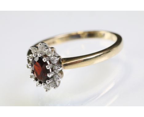 9ct gold hallmarked garnet and diamond cluster ring being set with an oval cut garnet to centre with a halo of diamonds. Hall