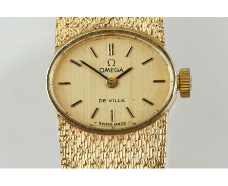 Omega De Ville 9ct gold ladies cocktail watch having an oval face with baton markers to the chapter ring, and mesh link brace