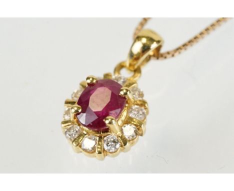 18ct gold pendant set with an oval cut ruby to centre with a halo of round cut diamonds. Pendant with 18ct hallmark to bale, 
