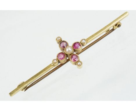 Early 20th Century 15ct gold ruby and pearl bar brooch. The brooch set with four round cut rubies with five half pearls. Mark