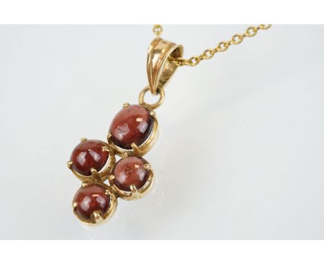 15ct gold and garnet cabochon pendant set with four cabochons with bale to top, mounted to a fine link chain with a spring ri