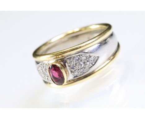 18ct gold two tone ruby and diamond ring. The ring being bezel set with a oval cut ruby to centre with pave set round cut dia