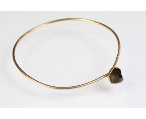 Rose gold bangle bracelet having a hook clasp set with a smokey quartz crystal. Unmarked, assessed as 9ct gold. Diameter appr