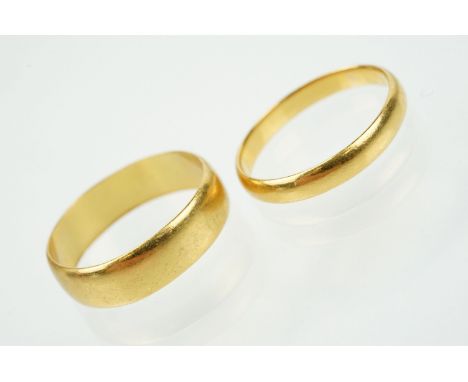 Two hallmarked 22ct gold wedding band ring to include one of wide 'D' form (hallmarked Birmingham 1915, size T) and a a thinn
