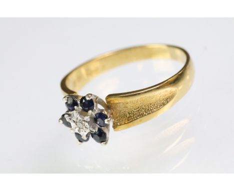 Hallmarked 18ct gold sapphire and diamond cluster ring having textured shoulders. Hallmarked London 1974. Size P. 