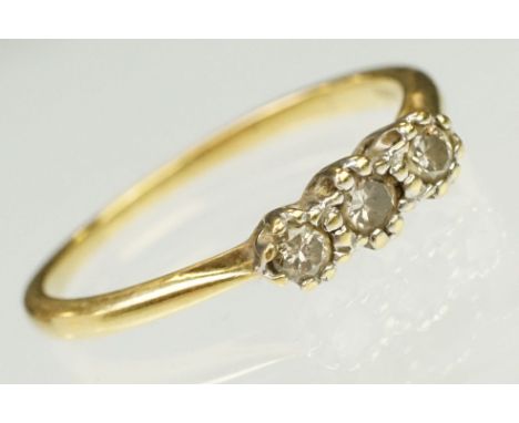 18ct yellow gold and diamond three stone ring. The ring being prong set with three round brilliant cut diamonds on pinched sh