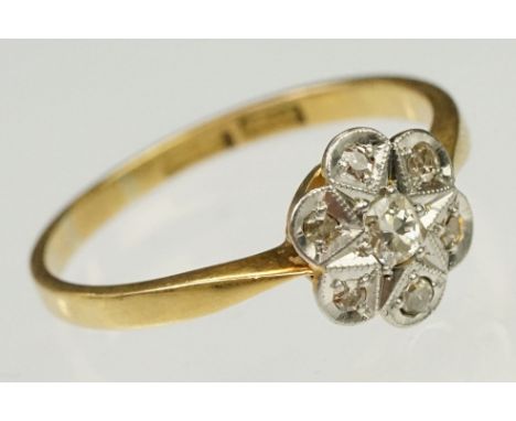 1920s 18ct gold, platinum and diamond daisy head ring being set with seven round cut diamonds on tapering shoulders. Band mar