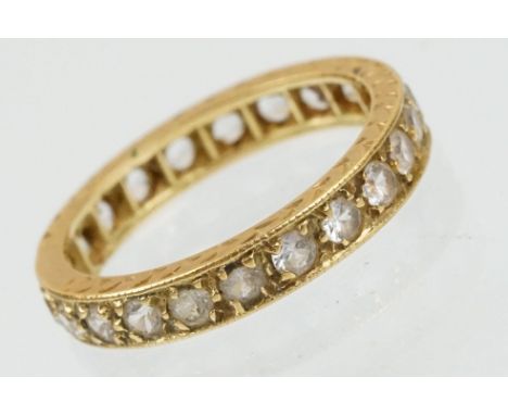 18ct and white stone eternity ring set with round cut white stones with incised detailing. Marked 18ct. Size J.5. 