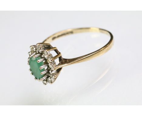 9ct gold hallmarked emerald and diamond cluster ring. The ring being set with an oval cut emerald surrounded by round single 