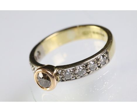 18ct gold tri tone diamond ring having a central round cut diamond set in a bezel setting with diamond accent stones to the s