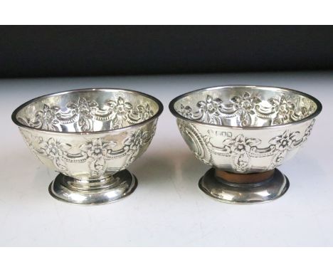 Pair of silver hallmarked footed bowls having moulded floral garlands and unengrved initial panels. Hallmarked London 1898, W