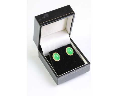 Pair of 14ct gold and jade stud earrings. The earrings being set with oval jade cabochons. Marked 14k. Heads measure 11mm. 