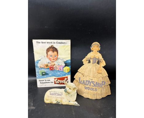 Three advertisements for British wool: a rectangular showcard depicting a child dressed in wool playing with wooden cubes spe