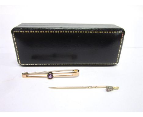 A 9CT GOLD STOCK PIN  Set with an amethyst & rose gold stick pin surmounted with a small champagne bottle (2)