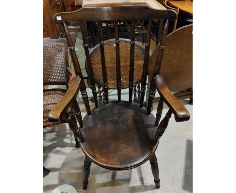 A 19th century stained wood ladder back rocking armchair; a stained wood spindle back armchair. 