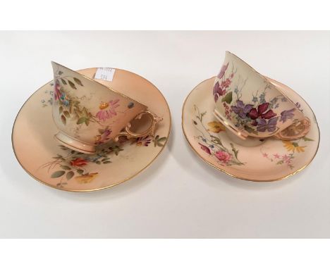 Two Royal Worcester cabinet cups and saucers decorated in polychrome against a peach blush ground The left hand side pair see