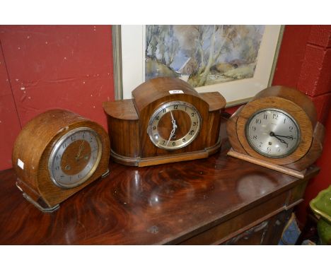 A  bow-fronted veneered and chromium mounted mantel clock, Arabic numerals, 24cm high, 38cm wide, c. 1935; others, similar (3