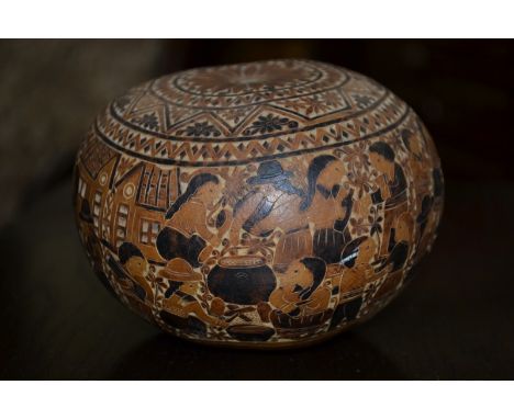 A Bolivian folk art carved nut, the surface extensively worked illustrating scenes of daily life, c.1900.