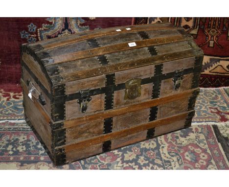 A dome topped, wood and metal bound travel trunk, c. 1920