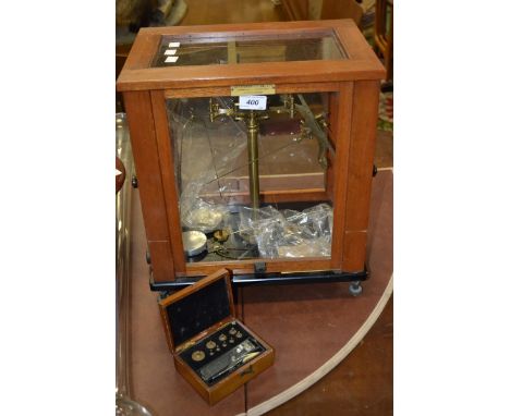 A set of brass balance scales, mahogany glazed case, with two sets of weights, Wolter's Balances