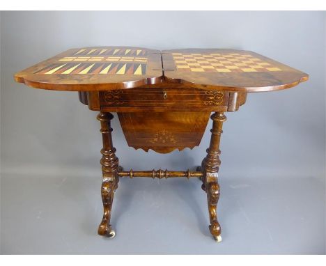 An Antique Walnut Recreation/Sewing Table, with decorative foliate boxwood inlay, lift-up lid to reveal an inlaid games table