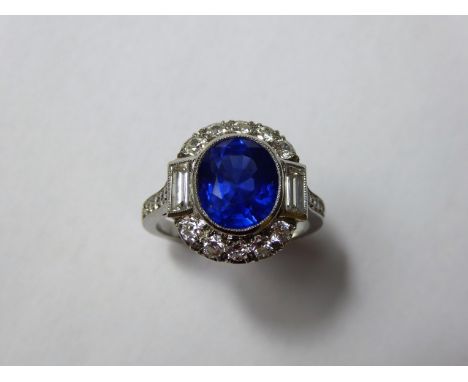 An Art Deco Natural 4.2 ct Royal Blue Burmese Sapphire and Diamond Ring. Set in platinum the vivid blue oval sapphire measure