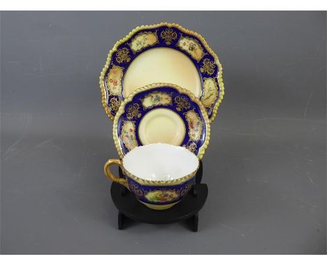 A Royal Worcester Cabinet Cup, Saucer and Plate, pattern no 5456, blush ware with cobalt blue border and floral decoration, a