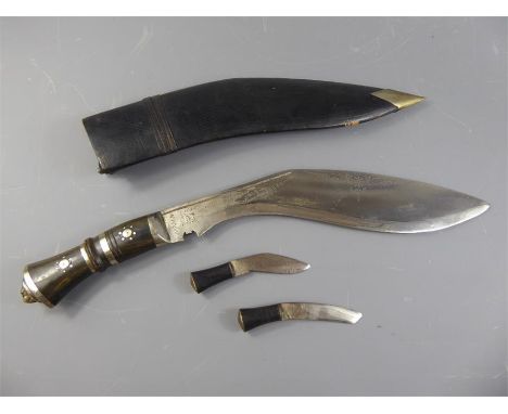 An Indian Souvenir Khukuri Set, horn handle with decorative inlay, contained within a incised leather scabbard, with two skin