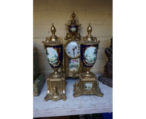 A reproduction brass and ceramic clock garniture,&nbsp;41cm high. 