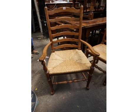 A set of eight reproduction oak and rush seated ladder back dining chairs, to include a pair of elbow chairs.&nbsp; 