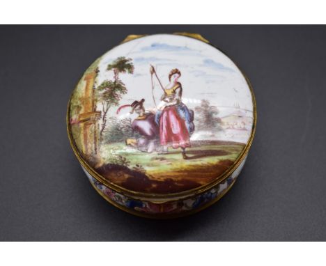 A late 18th century Birmingham enamel and gilt brass mounted circular box, painted to the hinged cover with figures in a land