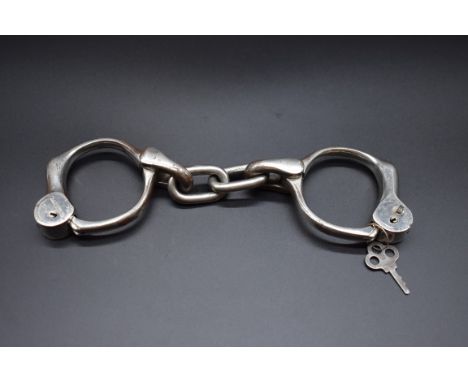 A pair of vintage American handcuffs, inscribe 'H&amp;R Arms Co, Worcester, Mass',&nbsp;with key. 