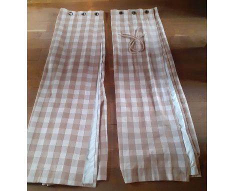 A pair of full length thick cotton curtains in tan and cream check having a  black out lining and ring top heading, each pane