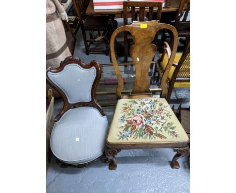 A Victorian mahogany nursing chair with upholstered seat and back on carved short cabriole legs, porcelain castors, and a Vic