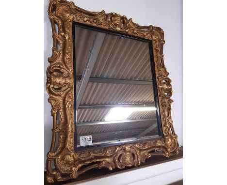 A decorative wall mirror, the modern glass panel in gilt plaster frame, overall measurements 59cms x 51cms