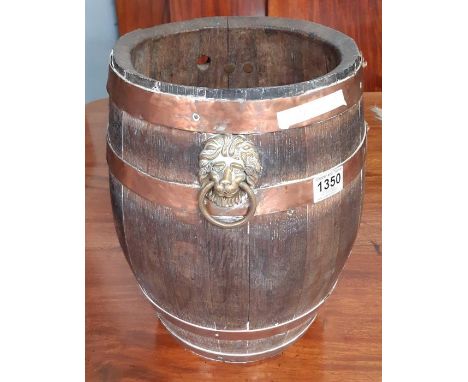 A small coopered oak barrel with copper bands and brass lion mask ring handles now used as a stick stand, 38cms high