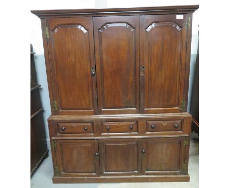 A late 18th century oak housekeeper's cupboard the two panel doors opening to fixed shelving with central fixed panel, simila