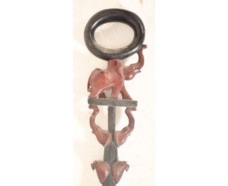 A vintage 20th century hand carved African tribal walking stick. The stick ebonised, with ring handle top mounted atop elepha